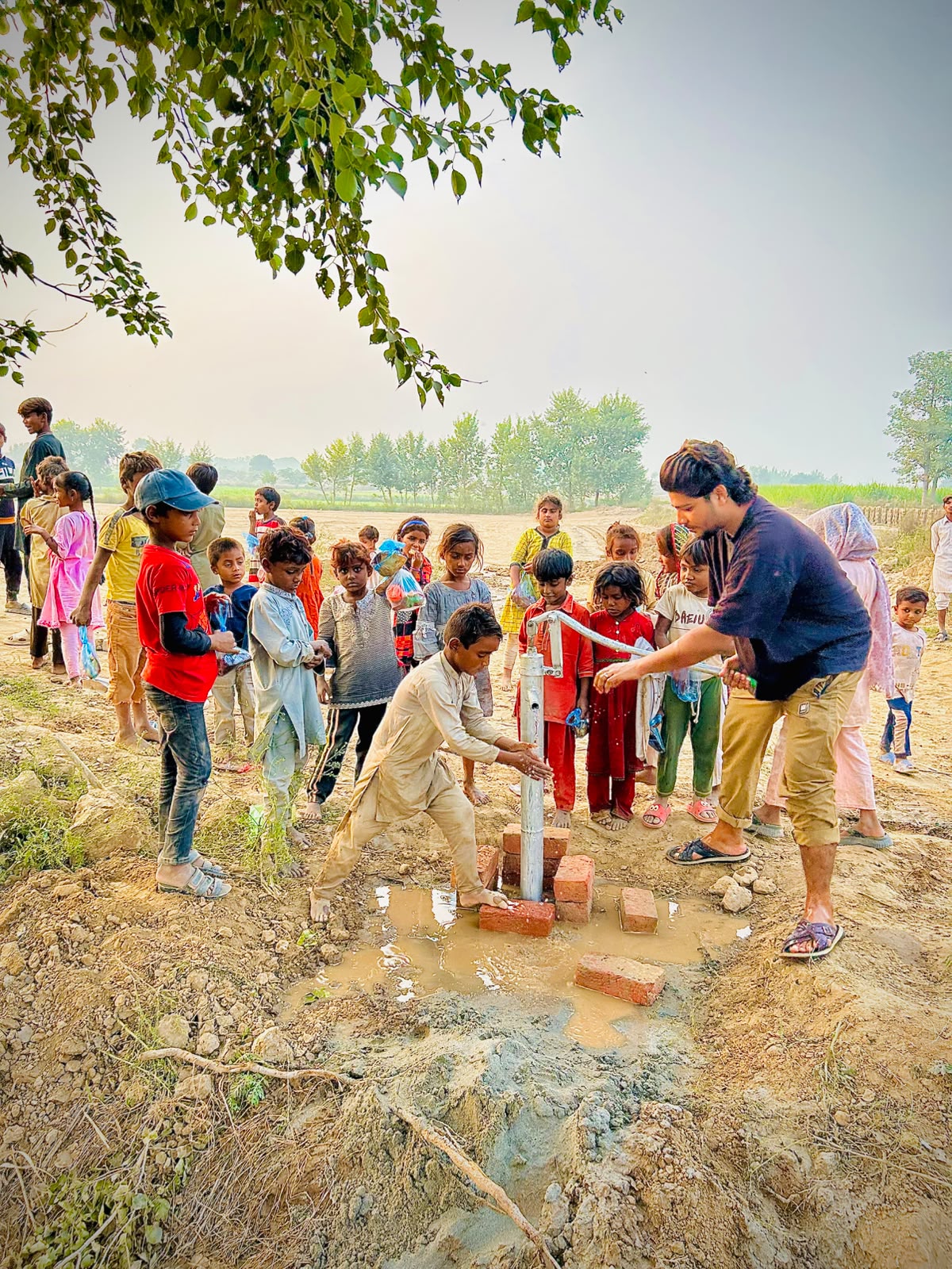 Children gathered at a hand pump